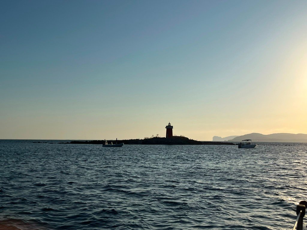 Escursione pomeridiana in barca davanti al faro rosso della costa di Alghero